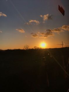 the sun is setting over an open field