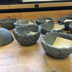 several bowls sitting on top of a wooden table with sticky notes stuck to the sides