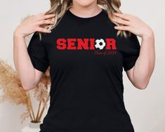 Class of 2024 Senior Soccer T-Shirt in Black, Great for a graduation gift! Introducing the ultimate blend of softness, style, and comfort! Our unisex t-shirt is like a cozy hug from your favorite person, but in clothing form. It's made from 100% combed and ring-spun cotton, which means it's as smooth as a baby's bottom and will feel like a dream against your skin. Plus, with a modern fit and a ton of color options, you'll look as good as you feel. Whether you're hitting the gym, lounging at home, or just want to show off your impeccable taste in fashion, this shirt has got you covered. Literally! Taking care of your t-shirt is easier than taking care of a houseplant, but just as important if you want it to thrive: -If your t-shirt is feeling a bit grubby, give it a wash in some cold water Black T-shirt With Heat Transfer Vinyl For School, Black Crew Neck T-shirt For School Spirit, Custom Print Black T-shirt For Graduation, Black T-shirt With Custom Print For Graduation, Black Crew Neck Top For Graduation, Graduation Letter Print Crew Neck T-shirt, Black Letter Print T-shirt For Graduation, Black T-shirt With Letter Print For Graduation, Black T-shirt With Graphic Print For Graduation