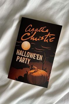 a book sitting on top of a bed next to a white comforter with the title halloween party