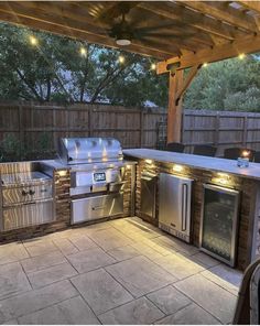 an outdoor kitchen with stainless steel appliances and lights