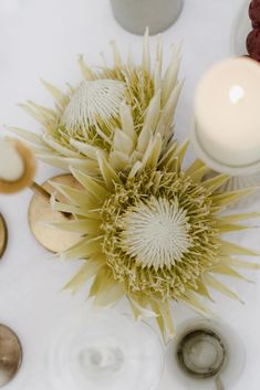 a white table topped with lots of different types of food and candles on top of it