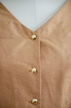 A homemade golden tan jacket, with puffed shoulders, gold faceted buttons, and good tailoring. It is unlined and light enough to be worn as a blouse. ☛ m e a s u r e m e n t s ☚ Bust: 32 Waist: 28 Shoulders: 13.5 Length: 21 ☛ d e t a i l s ☚ Era: 1990s Material: polyester Condition: excellent ☛ v i s i t t h e s h o p ☚ https://etsy.me/2Nd23kg ☛ instagram ┇ poppycockvintage ☛ facebook ┇ poppycockvintage Classic Gold Blouse For Workwear, Gold Formal Blouse With Button Closure, Gold Blouse With Button Closure For Formal Occasions, Gold Button-up Top For Work, Gold Button-up Top For Workwear, Gold Blouse With Buttons For Work, Gold Button-up Blouse For Work, Chic Gold Top With Button Closure, Chic Gold Tops With Button Closure