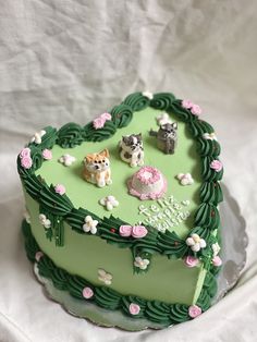 a heart shaped cake decorated with small dogs and flowers