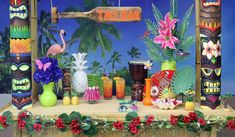 tiki decorations are displayed on a mantel with flowers and palm trees in the background