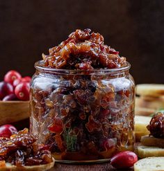 a jar filled with cranberry sauce next to crackers