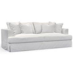 a white couch with lots of pillows on the top and bottom cushions, sitting against a white background