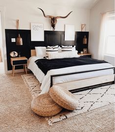 a bedroom with a large bed and cow skull on the wall above it's head