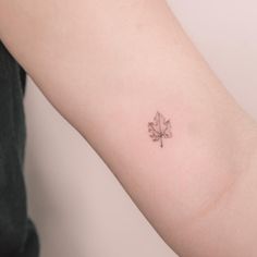 a small leaf tattoo on the arm