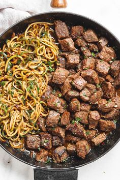 a pan filled with meat and noodles on top of a table next to an instagram page