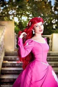 a woman with red hair wearing a pink dress