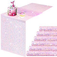 a pink table topped with a cake covered in frosting and sprinkles