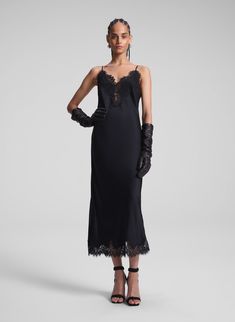 woman wearing black slip dress and black leather gloves Black Silk Dress With Lace Trim, Black Camisole Slip Dress With Lace Trim, Minimalist Heels, Black Lace Trim Midi Slip Dress, Sculptural Earrings, Black Lace Trim Camisole Slip Dress, Black V-neck Slip Dress With Lace Trim, Black Lace Midi Dress, Lace Midi