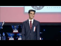 a man in a suit and tie standing on stage