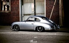 a silver car parked in front of a brick building