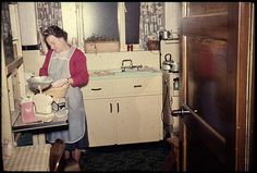 an old photo of a woman in the kitchen