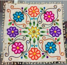 an embroidered square with colorful flowers on it