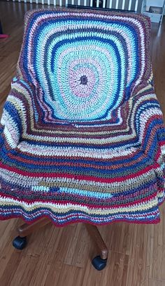 a crocheted chair sitting on top of a hard wood floor