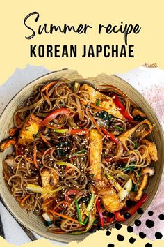 a bowl filled with noodles and vegetables on top of a white table next to a pink napkin