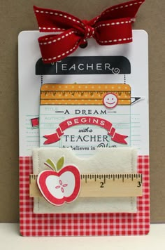 a teacher's magnet with a red ribbon on it and an apple in the middle