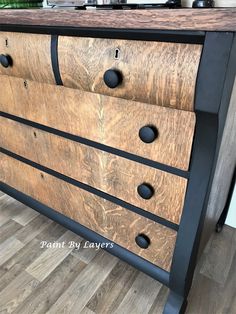 a wooden dresser with black metal handles and knobs on the drawers is shown in this image