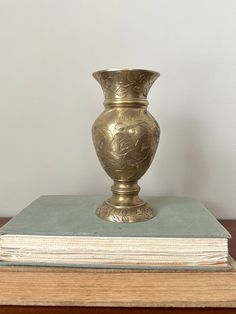 a gold vase sitting on top of a book