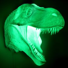 a close up of a dinosaur's head with its mouth open and glowing in the dark