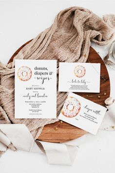 the wedding stationery is laid out on a wooden platter with napkins and paper