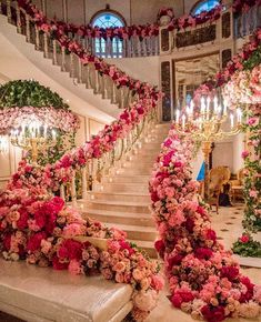 an elaborate staircase decorated with pink flowers and greenery for a wedding or special event