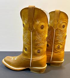 The Sunflower is built for durability with its Goodyear welt construction and leather sole. The unique stitching pattern, inspired by the flower itself, provides a striking visual aesthetic. From cowgirl to ranchers and any boot lover, the Sunflower is an ideal selection for anyone. **Here are just a few of the features that make the Sunflower so special:** All-leather Handcrafted construction Leather sole Beautiful stitching design pattern Durable and long-lasting Comfortable and stylish Country Style Snip Toe Moto Boots For Rodeo, Country Style Moto Boots With Snip Toe, Yellow Western Leather Boots, Country Style Fitted Moto Boots For Rodeo, Country Style Fitted Moto Boots For Ranch, Fitted Country Style Moto Boots For Ranch, Hand Tooled Country Boots For Fall, Country Style Hand Tooled Boots For Ranch, Country Style Hand-tooled Boots For Ranch