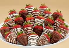 chocolate covered strawberries are arranged in a white platter on a beige tablecloth