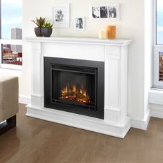 a living room with a fire place and pictures on the wall above it's mantle