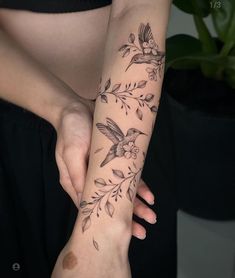 a woman's arm with flowers and birds on it