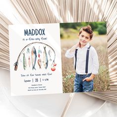 a boy in suspenders is holding up a birthday card