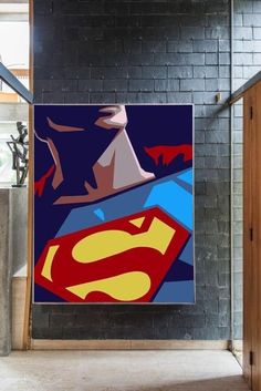 a superman poster hanging on the side of a brick wall next to a doorway with an open door