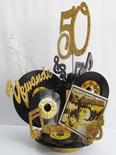 the 50th birthday cake is decorated with cd's and gold glitters for someone special