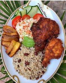 a white plate topped with rice, meat and veggies on top of a table