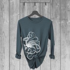 Women's Bella relaxed fit long sleeve T-shirt with an Octopus screen printed graphic design.  Super soft, stretchy, and comfy material.  Available with black or white ink! FIT: Follow the image size chart - Size down if you prefer a more fitted look.  Runs slightly large. But do check size chart if not sure.     - Long Length -  Bella 4.2 oz  Super Soft hand, Stretchy and Lightweight  -  Blended 52% Combed Ring Spun Cotton, 48% Poly -  Does not shrink ♥ All of our tees are hand-printed to order in our shop in Portland Oregon! ♥ RETURNS & EXCHANGES We gladly accept exchanges and returns if not worn.   Please follow the chest measurement size guide for fit if you are unsure.  We custom print to order and may charge a 15% restocking fee for returns only depending on the reason. ♥ About Our Te Screen Printing Graphic Design, Long Sleeve Tshirts, Moon Clothing, Tshirts For Women, Octopus Design, Women Graphic, Bella Canvas Tees, Night Shirt, White Ink