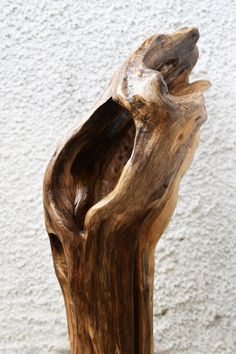 a piece of wood that has been carved into the shape of a tree trunk with its mouth open