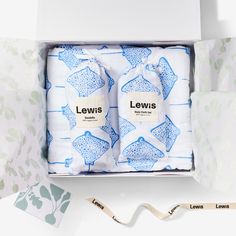 two baby swaddles in a gift box with the name lewis printed on them