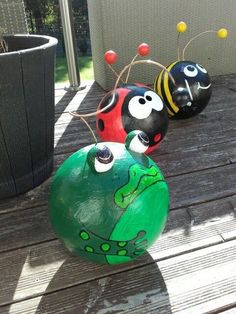 three painted balls sitting on top of a wooden table