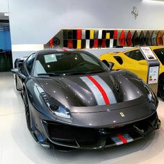 two sports cars are parked next to each other in a showroom with red, white and blue stripes on them