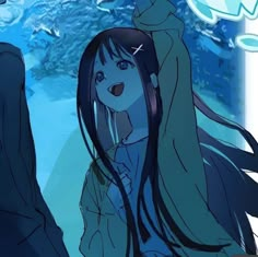 a girl with long hair standing in front of an aquarium