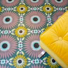 a yellow cushion sitting on top of a colorful floor