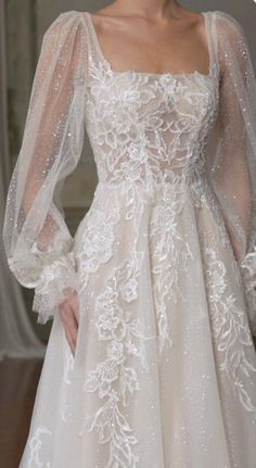 a woman in a wedding dress with long sleeves