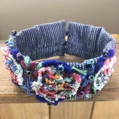 a close up of a bracelet on top of a wooden table next to a wall