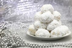 a white plate filled with powdered sugar covered donuts