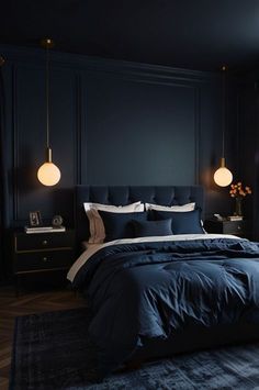 a bedroom with dark blue walls and bedding, two lamps on either side of the bed