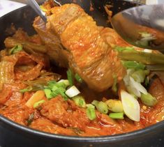 a pan filled with meat and vegetables on top of a table