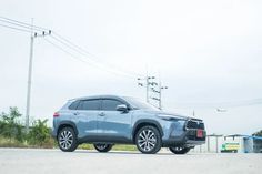 a blue suv is parked on the side of the road in front of power lines